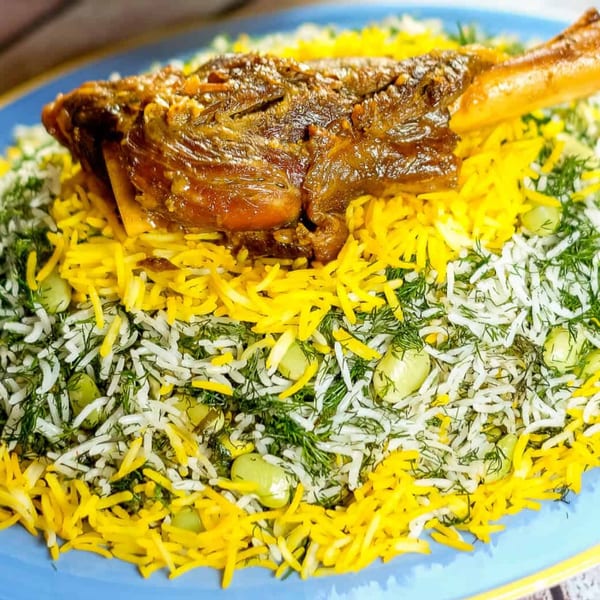 A Persian lamb shank with dill and fava bean rice, garnished with saffron rice.